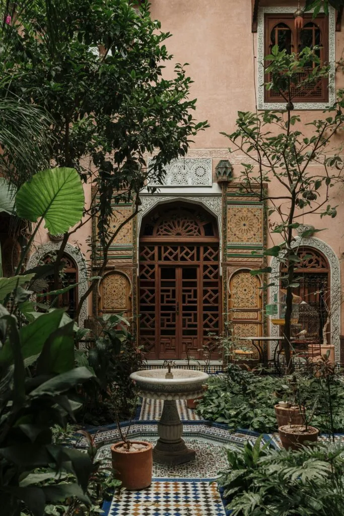 Beautiful Moroccan courtyard with greenery and intricate artistic elements.