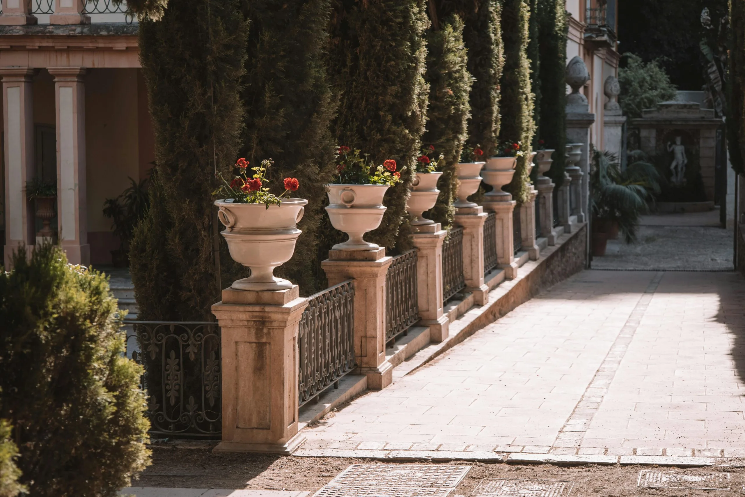 Serene view of a courtyard in Valencia with decorative potted plants lining the walkway.